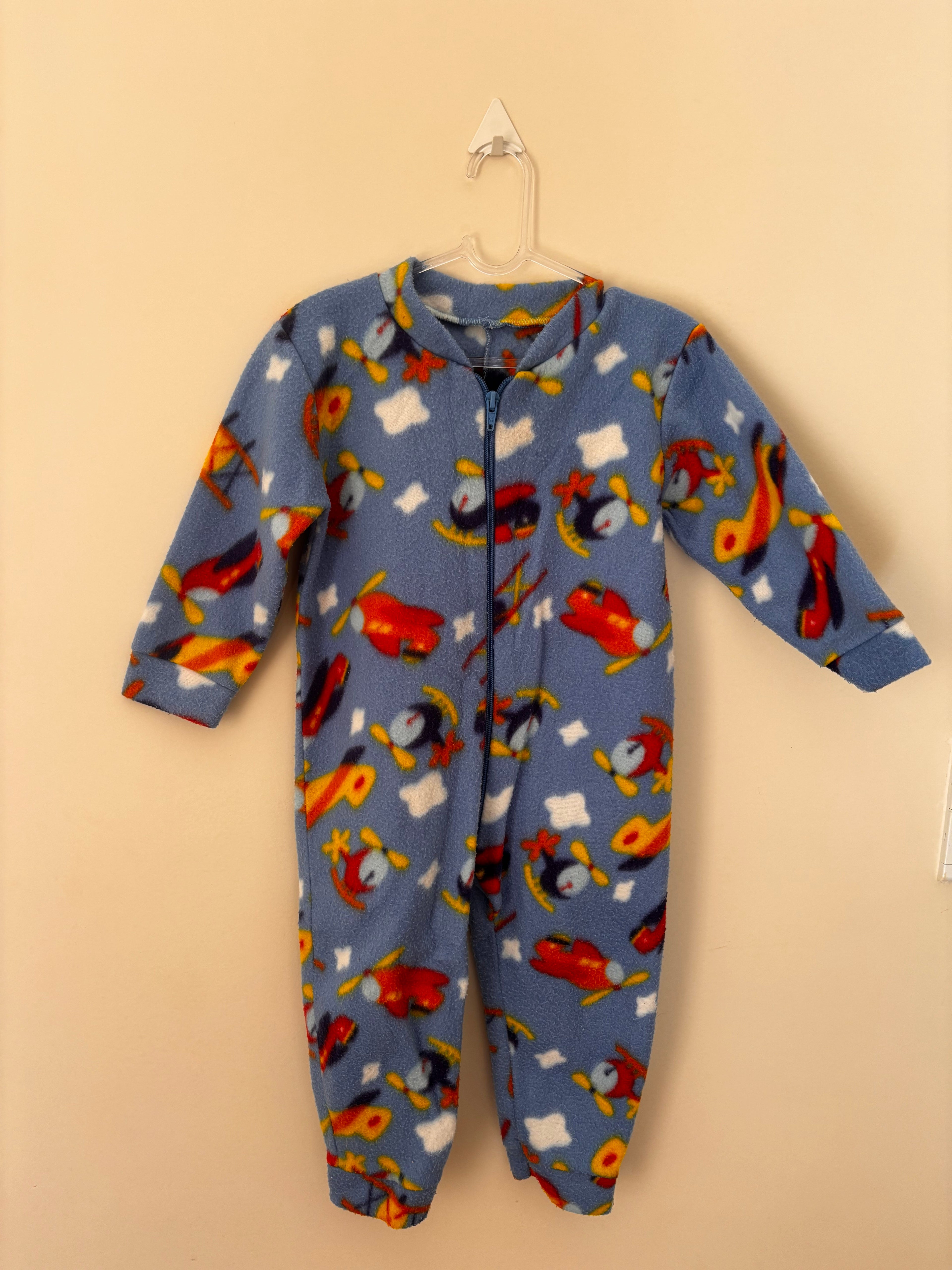Macacão pijama fleece azul com estampa de aviões e helicópteros